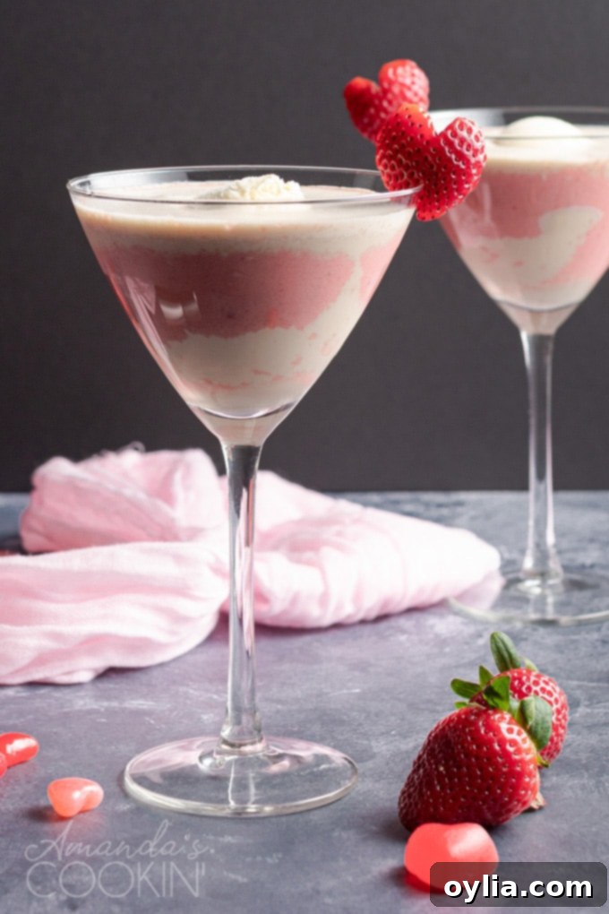 This Valentine's Mudslide adds fresh strawberries into the mix for a fresh and fruity take on a frozen cocktail classic. Make this for someone you love! #cocktails #valentinesday #mudslide #mudslidecocktail #partydrinks #strawberry #icecream #baileys #kahlua PINK MUDSLIDE IN A MARTINI GLASS