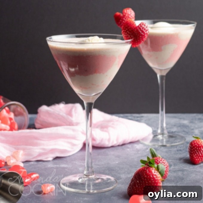 This Valentine's Mudslide adds fresh strawberries into the mix for a fresh and fruity take on a frozen cocktail classic. Make this for someone you love! #cocktails #valentinesday #mudslide #mudslidecocktail #partydrinks #strawberry #icecream #baileys #kahlua pink mudslide with strawberry heart garnish