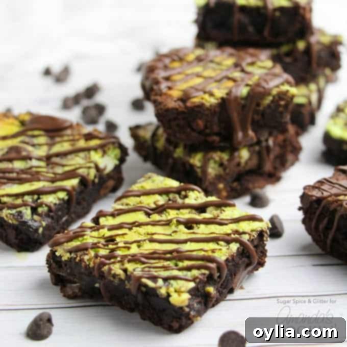 Squares of marbled mint cheesecake brownies neatly arranged on a cooling rack.
