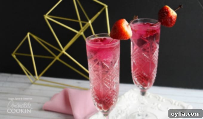 Close-up of Cupid's cocktail with a strawberry garnish and pomegranate seeds