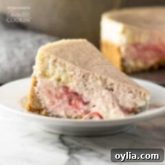 Marbled Strawberry Cheesecake 6 A tempting slice of homemade strawberry swirl cheesecake on a pristine white plate, showcasing its creamy texture and fruity ribbons, inviting you to indulge.