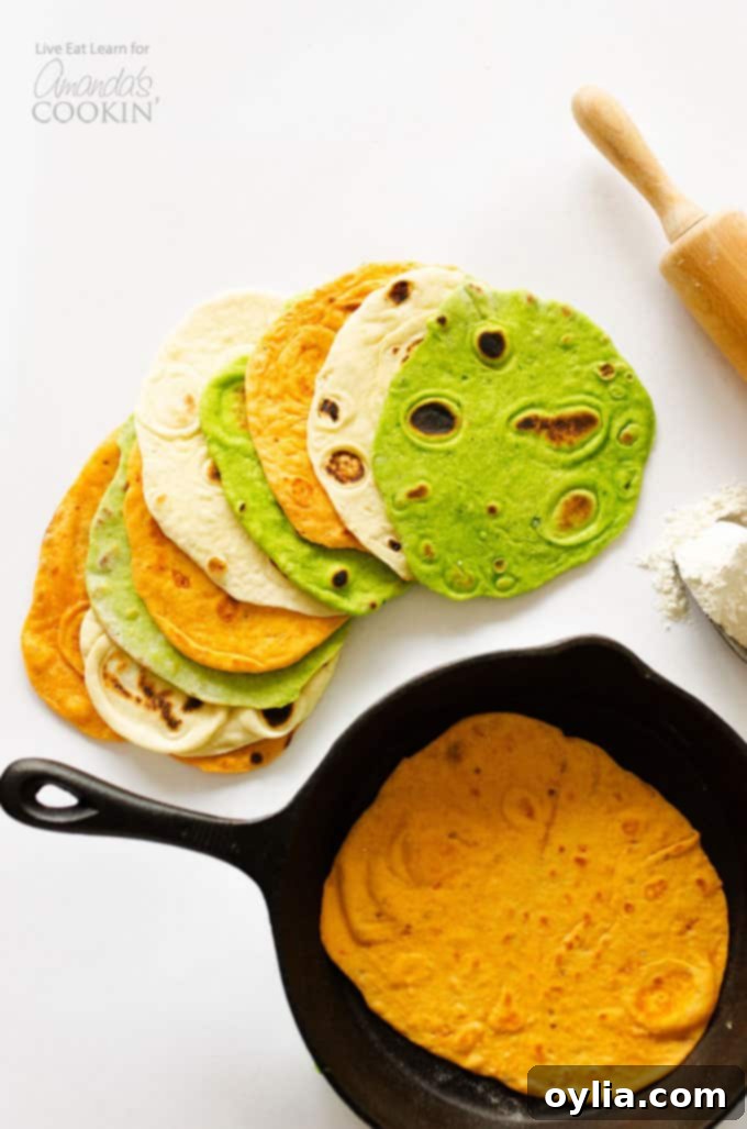 An overhead picture of a homemade tortilla resting in a skillet and multiple kinds of homemade tortillas resting on a white cutting board.