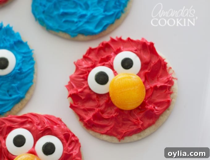 Close-up of a delightful Elmo cookie, with other colorful cookies blurred in the background.