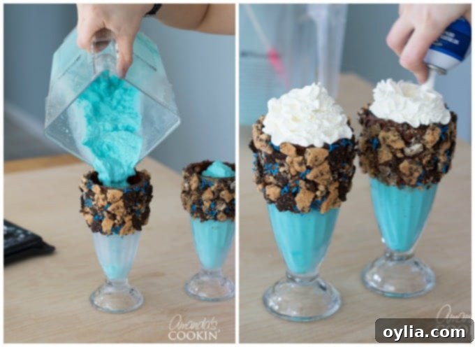 A vibrant blue Cookie Monster Freak Shake mixture being poured into a chilled, cookie-decorated glass, ready for final assembly.