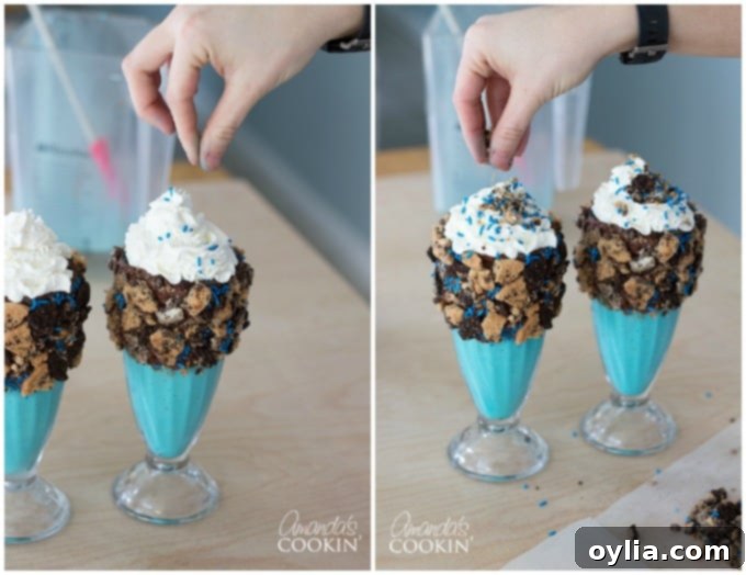 Whipped cream-topped blue milkshakes being decorated with blue sprinkles and leftover cookie crumbles, adding to the Cookie Monster theme.