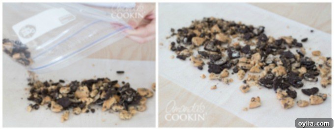 Cookie crumbles, a mix of Chips Ahoy and Oreos, spread out evenly on a piece of parchment paper, ready for decorating milkshake glasses.