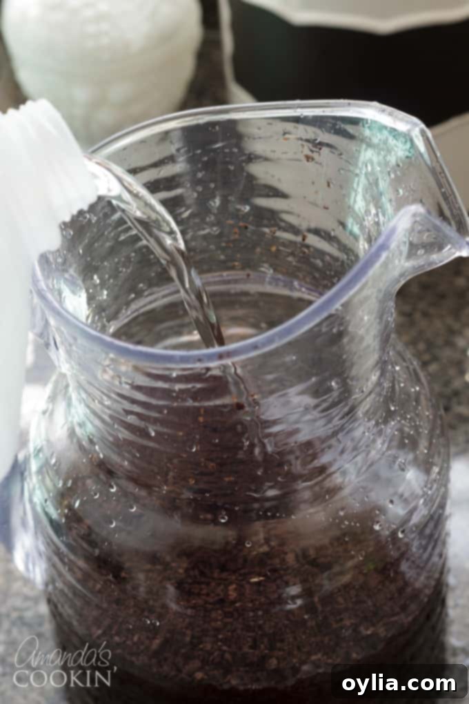 Place the ground coffee into a 2-quart pitcher and fill the pitcher with fresh water. Stir the mixture to make sure all the beans are wet.