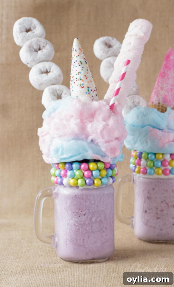 two purple milkshakes with donuts and marshmallows