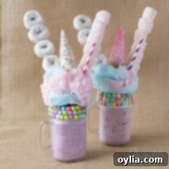 two purple milkshakes with donuts and marshmallows