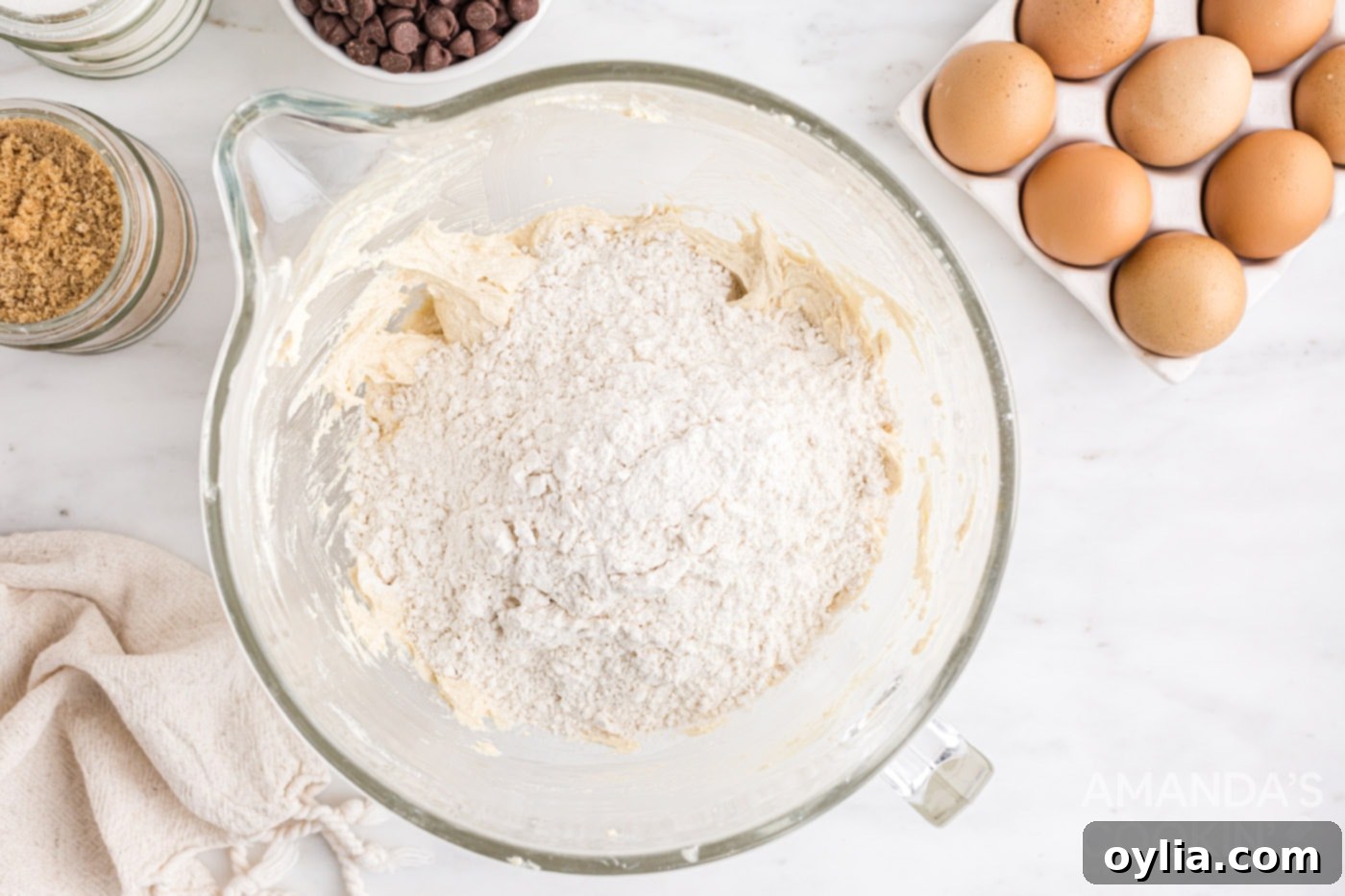 flour mixture added to cookie dough in a bowl