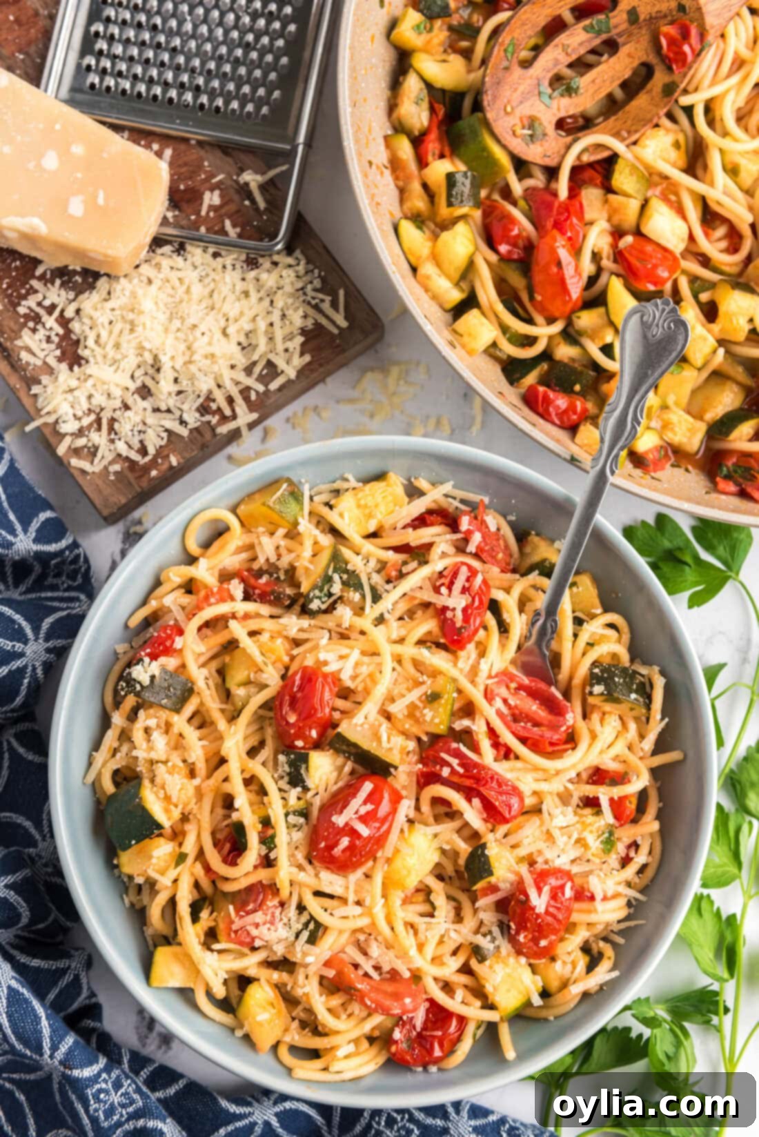 Bowl of Simple Zucchini Tomato Pasta topped with fresh parmesan cheese and herbs