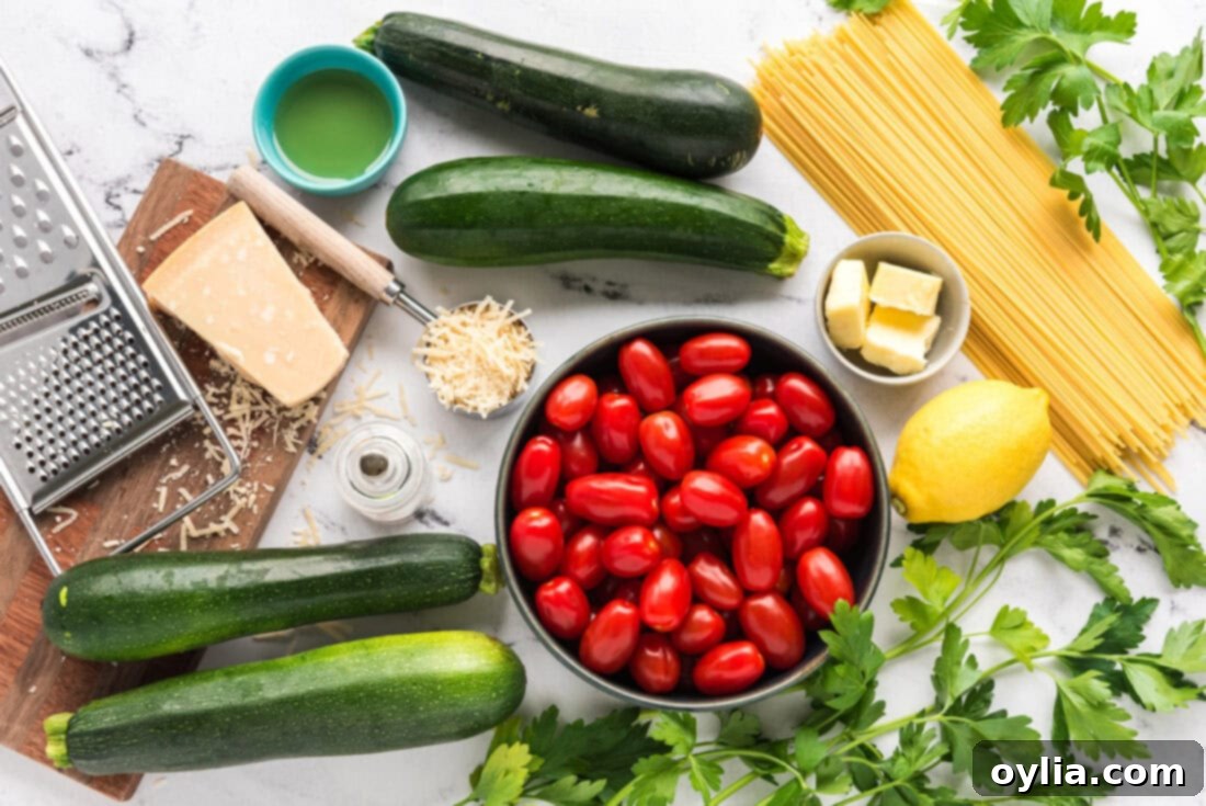 Fresh ingredients laid out for Simple Zucchini Tomato Pasta: zucchini, grape tomatoes, fresh parsley, lemon, olive oil, and butter