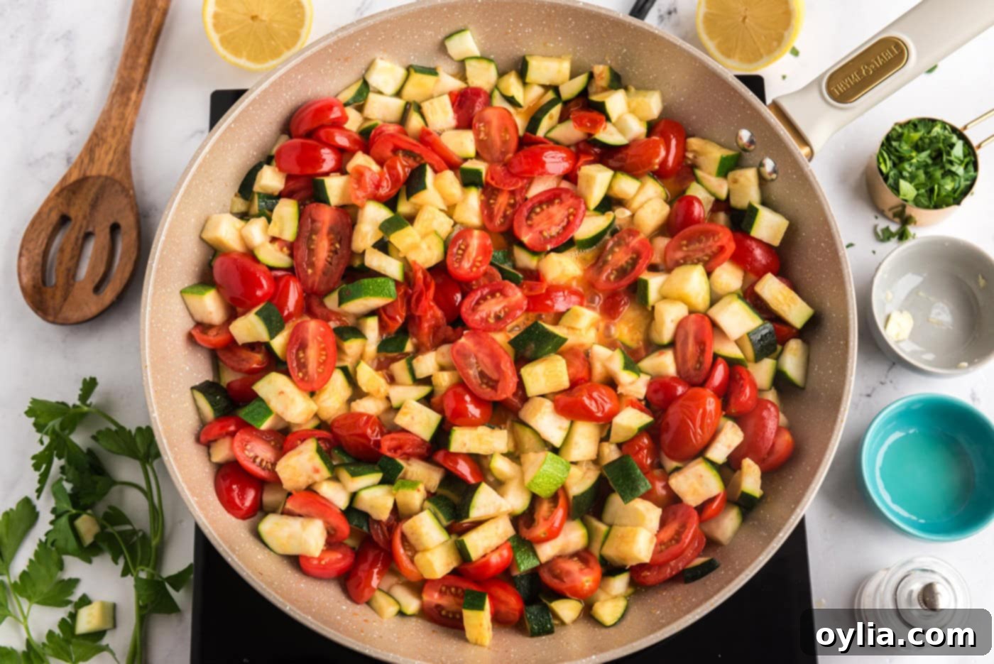 cooked zucchini and tomatoes in a skillet, showing the vegetables softened and releasing juices