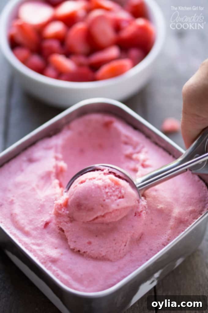 Scooping strawberry frozen yogurt, highlighting its creamy texture