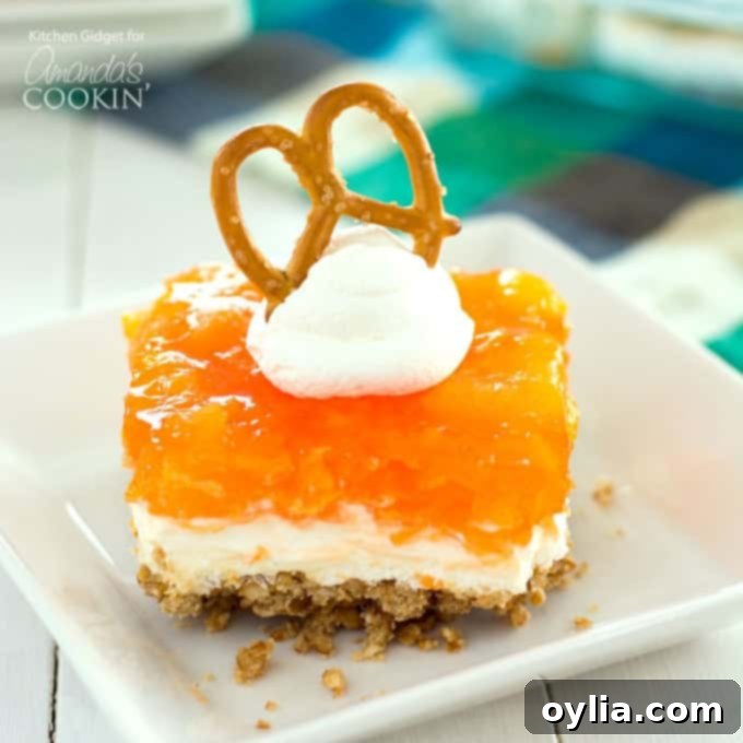 mandarin orange and cream cheese dessert with a bright orange jello top layer