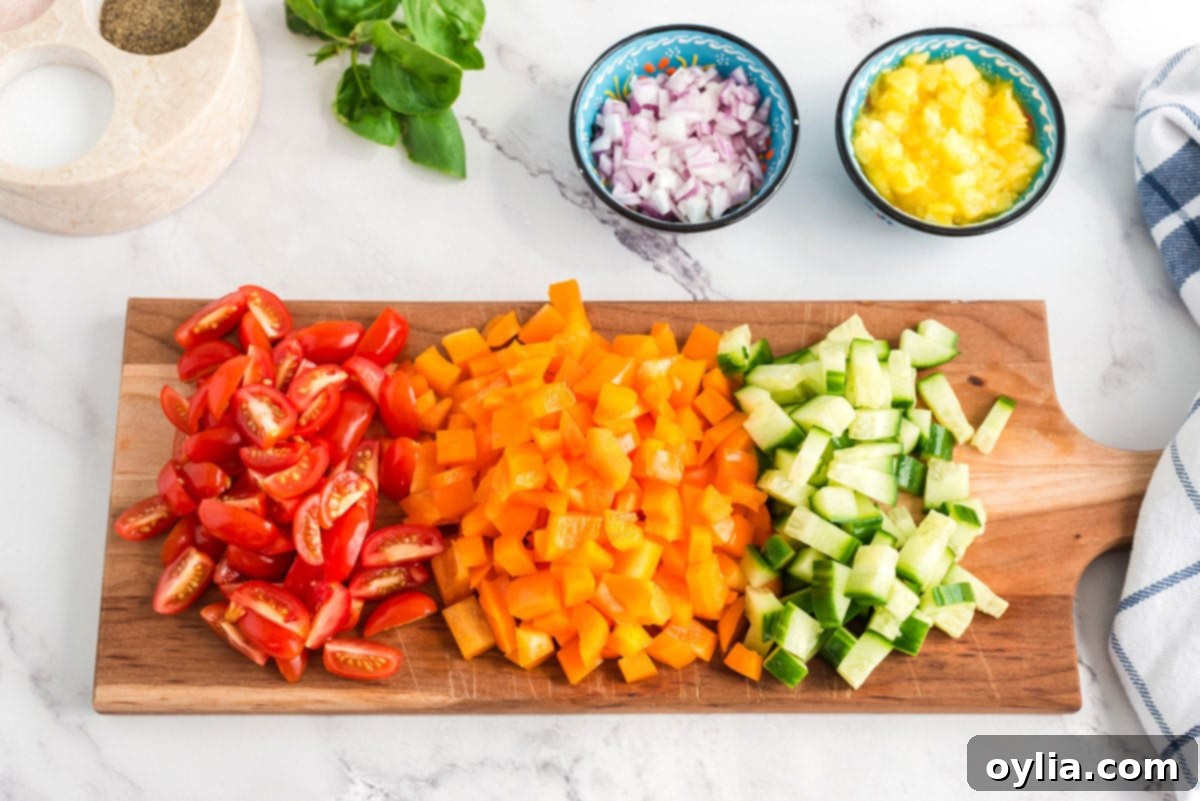 Various chopped vegetables neatly arranged on a cutting board, ready for the pasta salad.