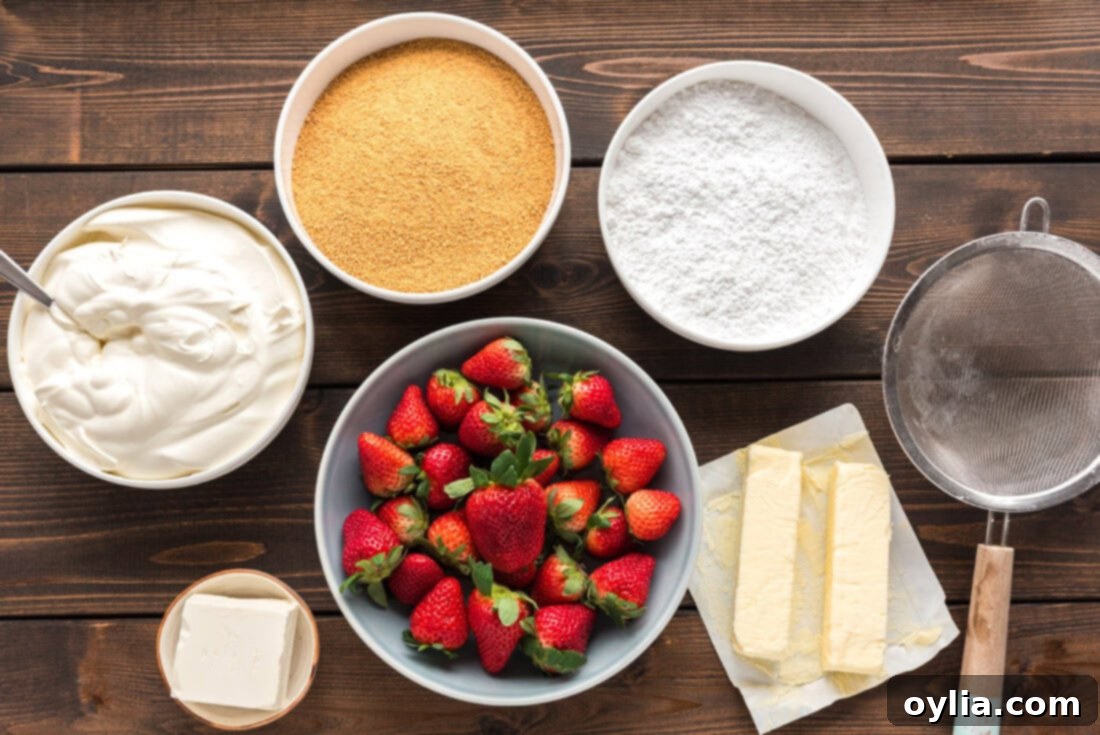 Collection of fresh ingredients laid out for making Strawberry Dream Dessert, including strawberries, cream cheese, butter, and graham crackers