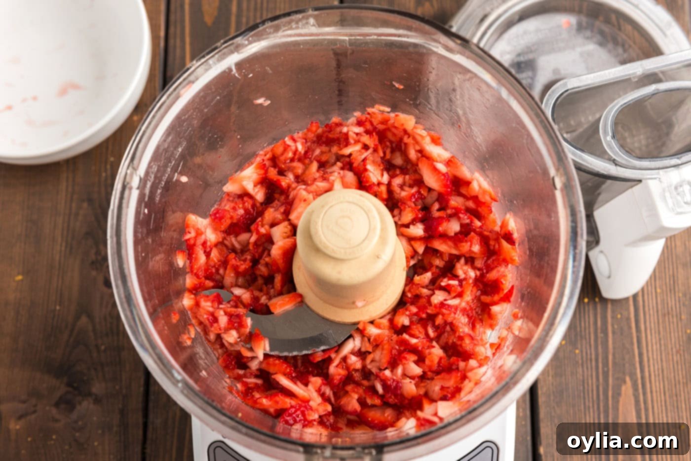 Fresh strawberries pulsed into chunky pieces in a food processor