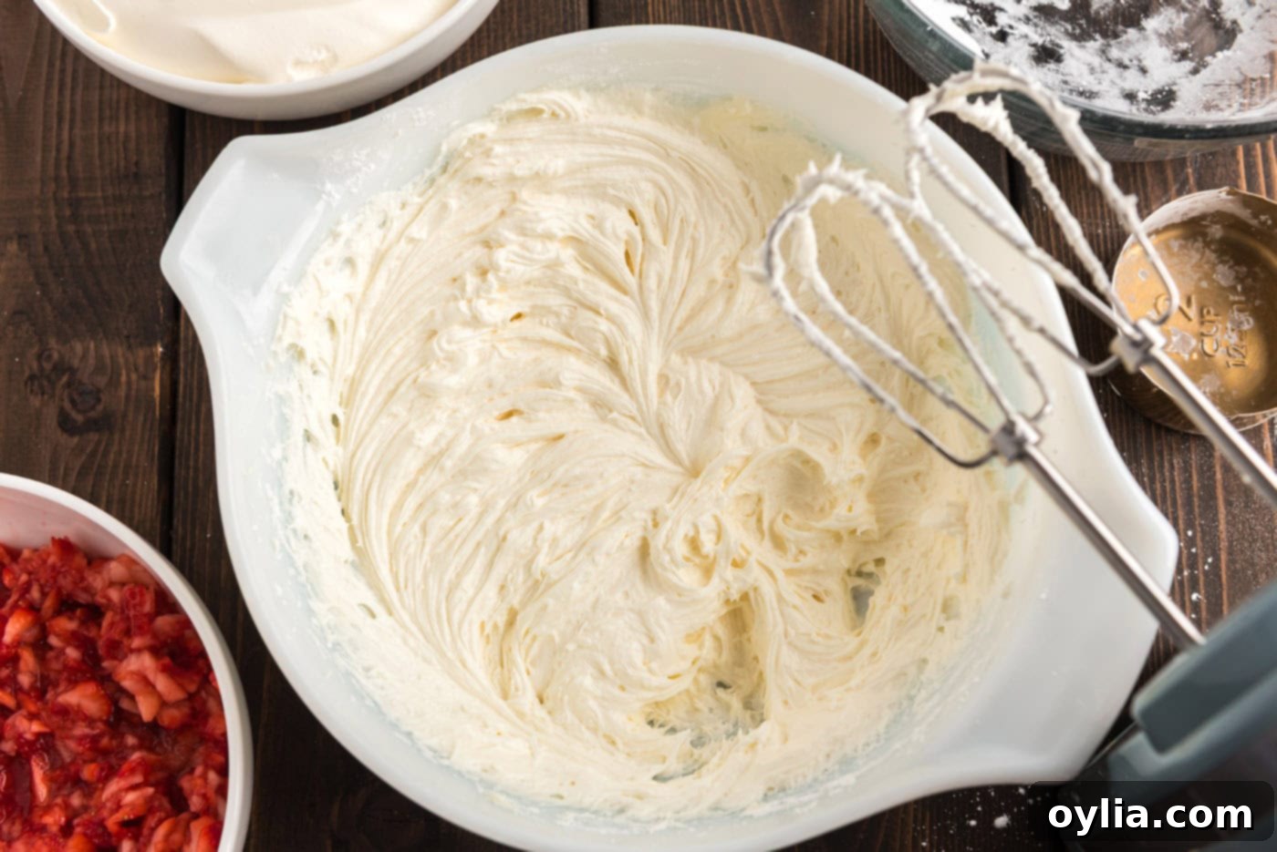 Cream cheese and butter mixture being beaten to creamy perfection with an electric mixer
