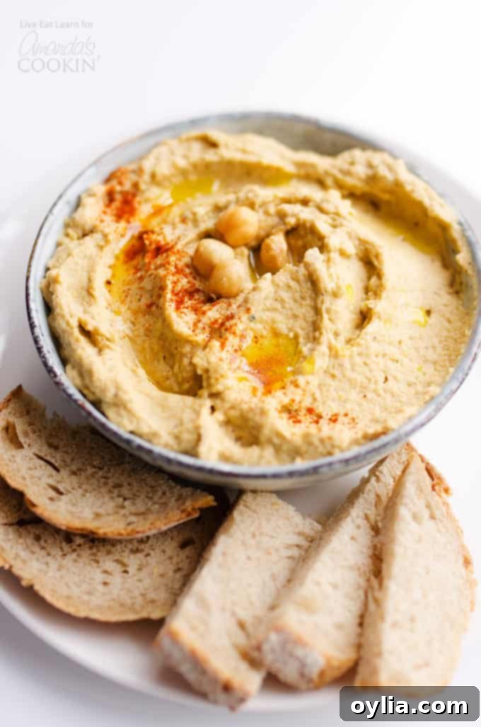 baba ganoush hummus in bowl with bread, garnished with paprika and olive oil