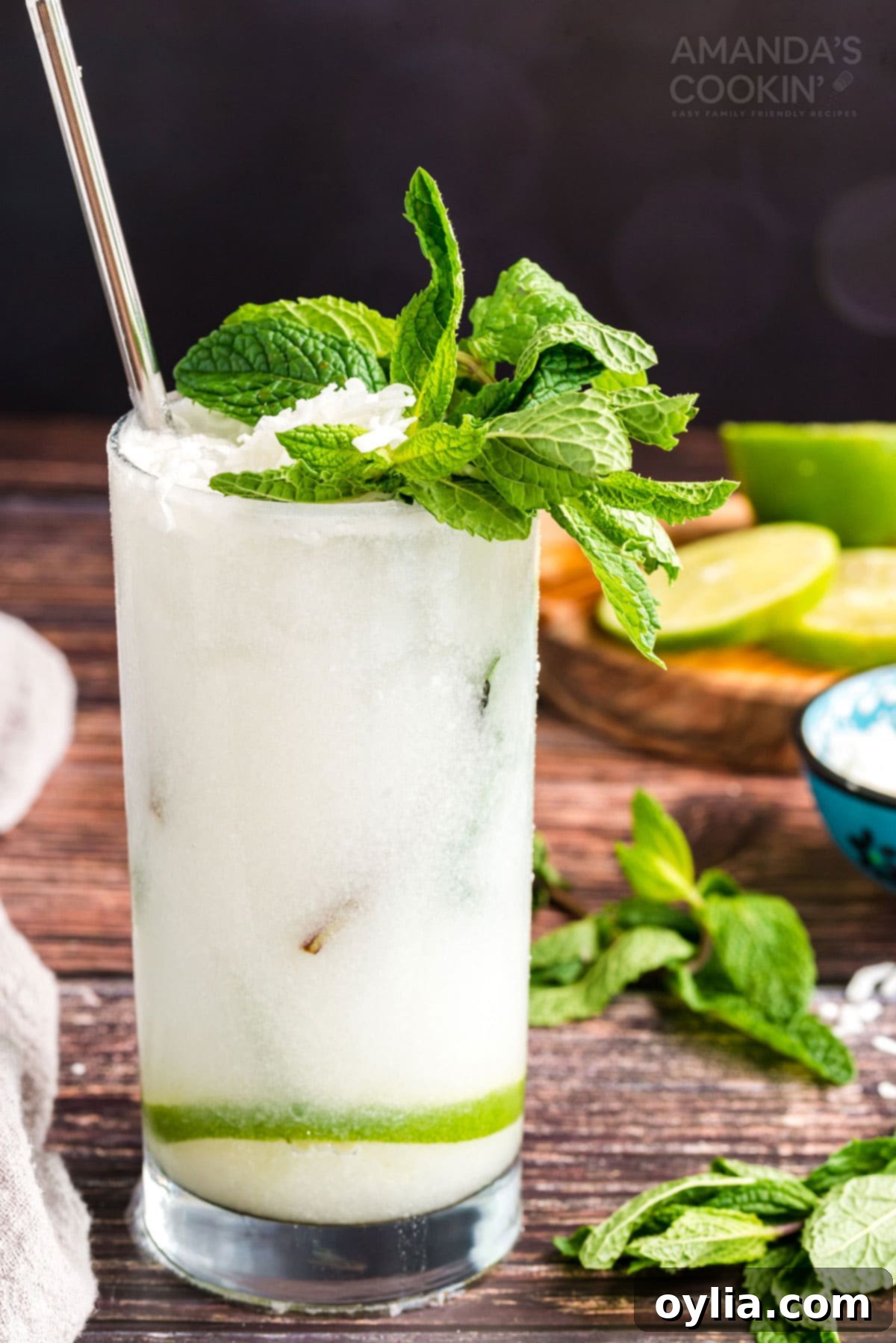 This refreshing Coconut Mojito is made with fresh cooling mint, coconut rum, cream of coconut and club soda. A delicious and tropical cocktail for summer! Glass of refreshing Coconut Mojito garnished with fresh mint leaves and a lime wheel, ready for summer