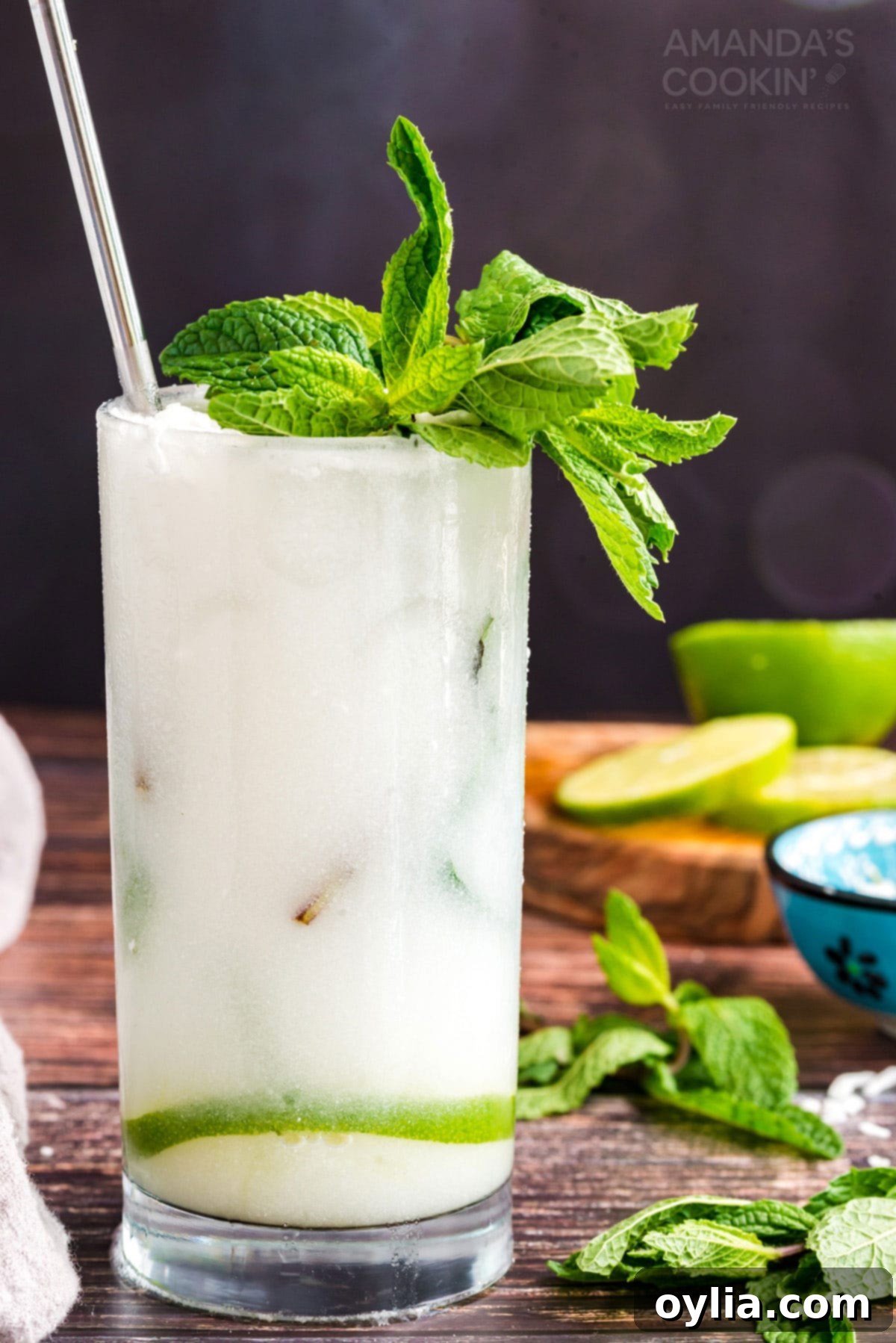 This refreshing Coconut Mojito is made with fresh cooling mint, coconut rum, cream of coconut and club soda. A delicious and tropical cocktail for summer! A refreshing Coconut Mojito cocktail in a tall glass, featuring coconut rum and cream of coconut, with garnishes of mint and lime.