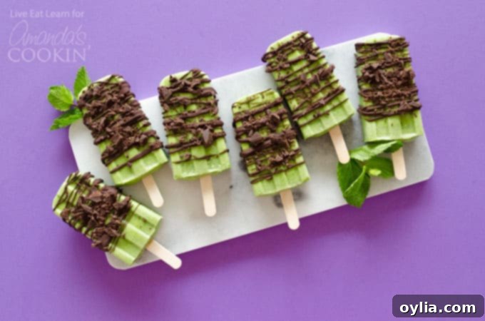 Three Coconut Mint Chocolate Popsicles on a wooden board