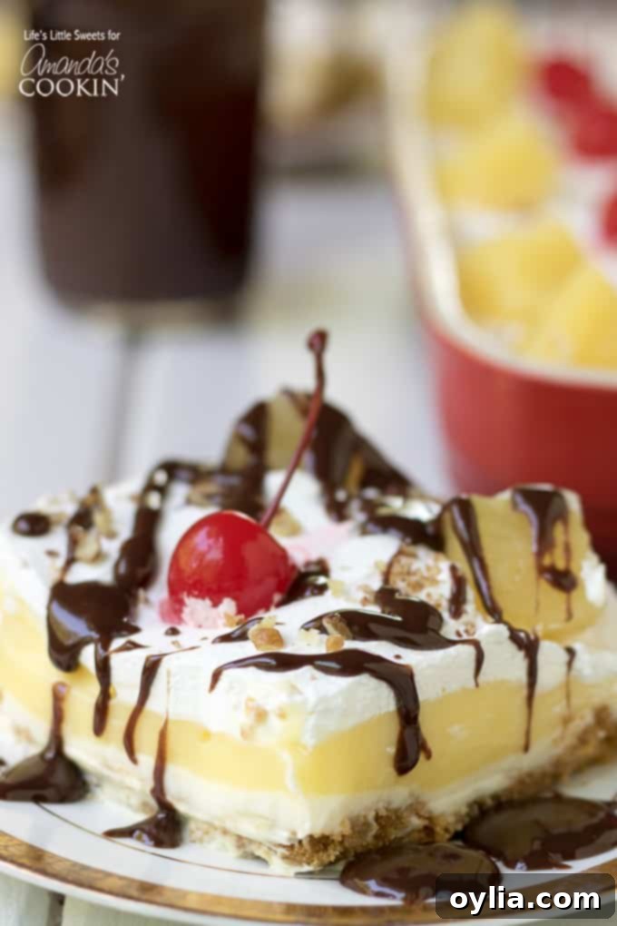 Banana Split Dessert Recipe - Top view of a layered dessert with banana slices, cherries, and chocolate drizzle