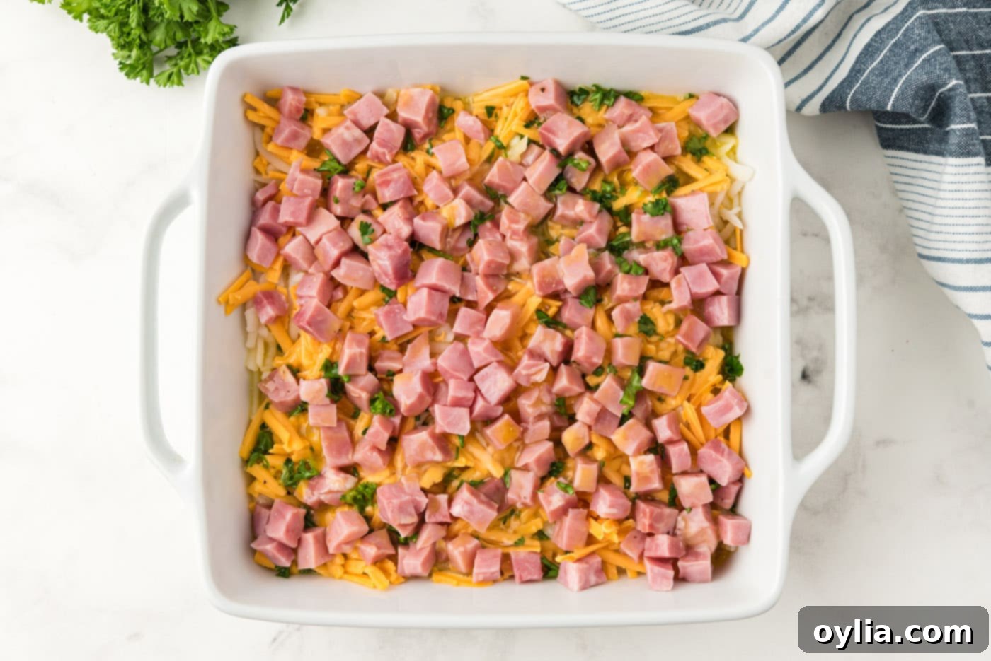 Breakfast casserole in a dish with egg mixture poured over the layers