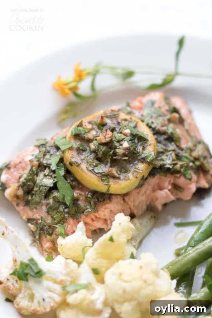 Sheet Pan Salmon with lemon slices on top, surrounded by roasted cauliflower