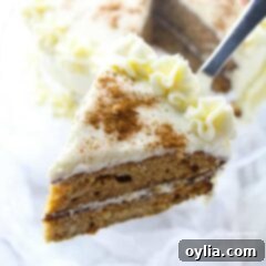 Harvest Spice Delight 2 A slice of spice cake on a spatula, showcasing its moist texture, two layers, and creamy, thick frosting, ready to be served.