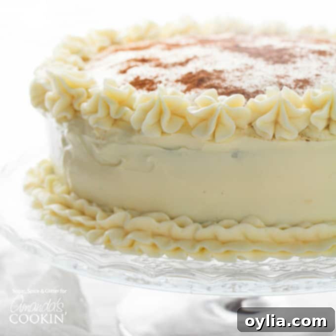 Beautifully frosted Fall Spice Cake, whole and uncut, lightly dusted with cinnamon, on a rustic background. Perfect for a holiday spread.