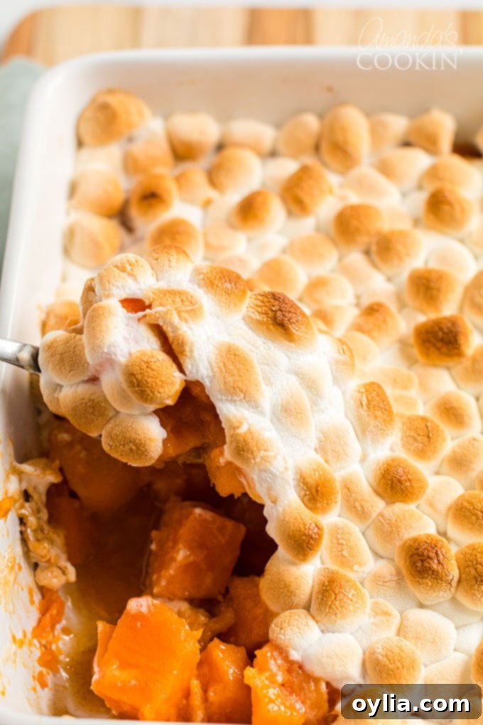 scooping candied yams with browned marshmallows from pan