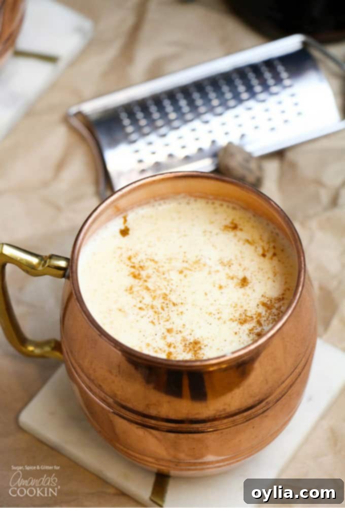 Rich, creamy homemade eggnog cocktail in a copper mug, generously garnished with freshly grated nutmeg.