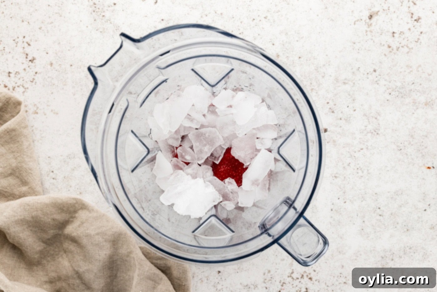ice on top of strawberries in a blender