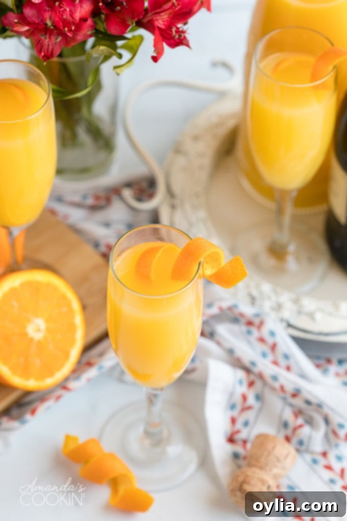 A perfectly prepared glass of mimosa with an orange twist garnish.