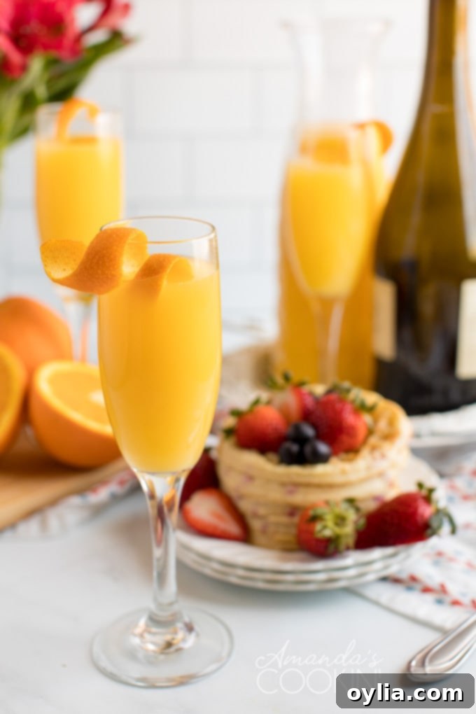 Three mimosas served with waffles in the background, ready for brunch.