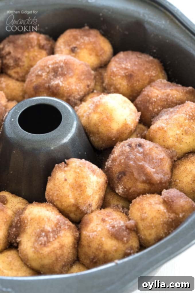 dough balls coated in cinnamon sugar in bundt pan