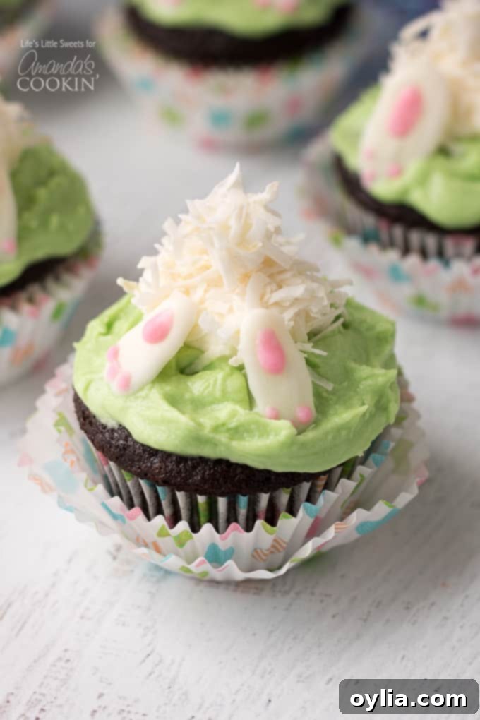 Close-up of a bunny butt cupcake with a chocolate cupcake base, green frosting, marshmallow bunny, and white chocolate feet, perfect for Easter.