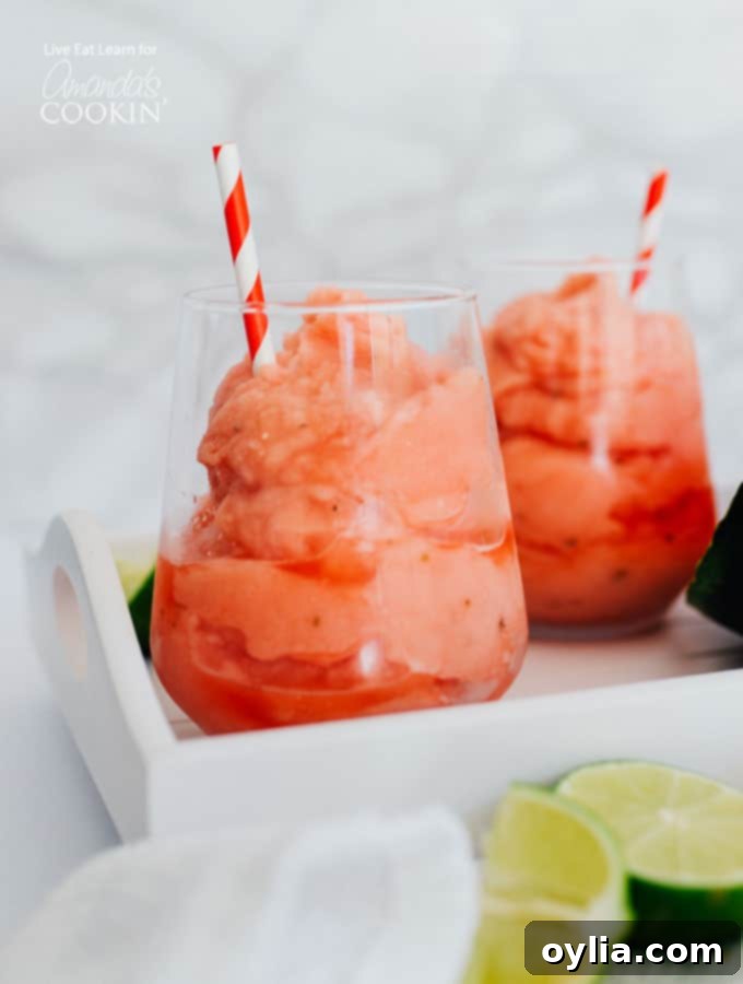 watermelon malibu slush drink in a glass with a straw and watermelon slices