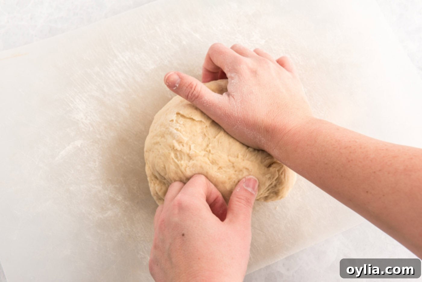 hands kneading dough ball
