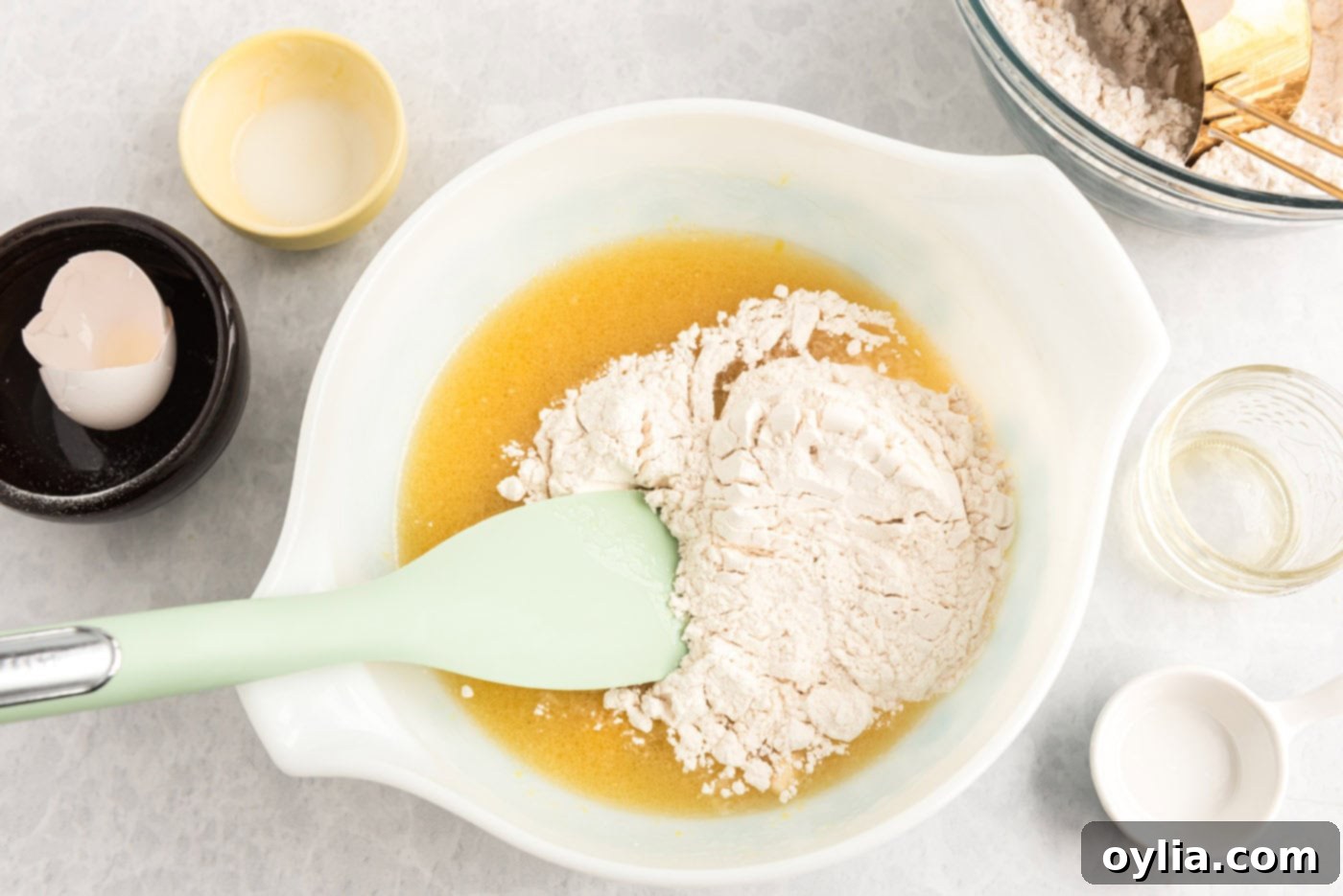 mixing flour into wet ingredients in bowl