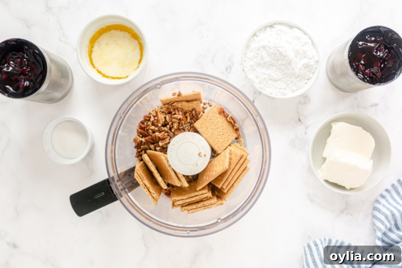 Graham crackers and pecans being blended in a food processor for the crust.