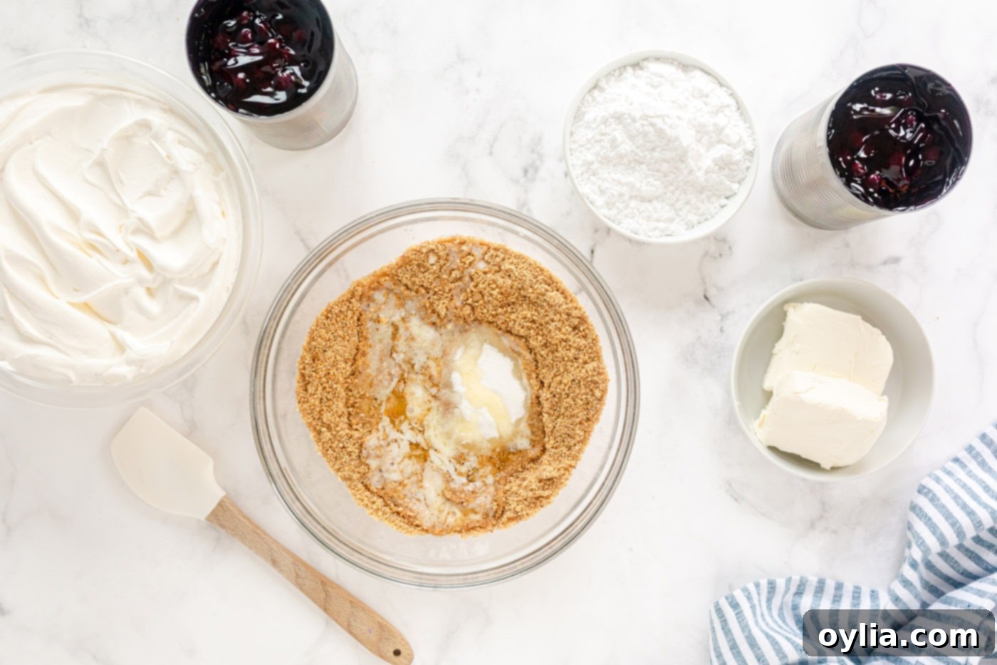 Butter, sugar, and grounded graham crackers in a food processor, ready to be mixed for the crust.