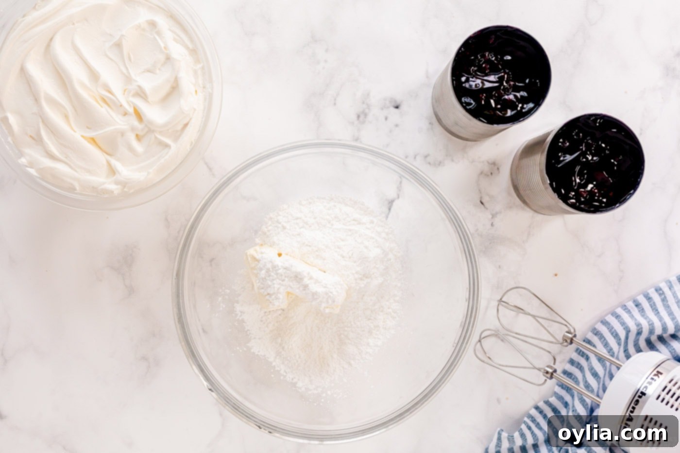 Cream cheese and powdered sugar in a bowl, being mixed until smooth.
