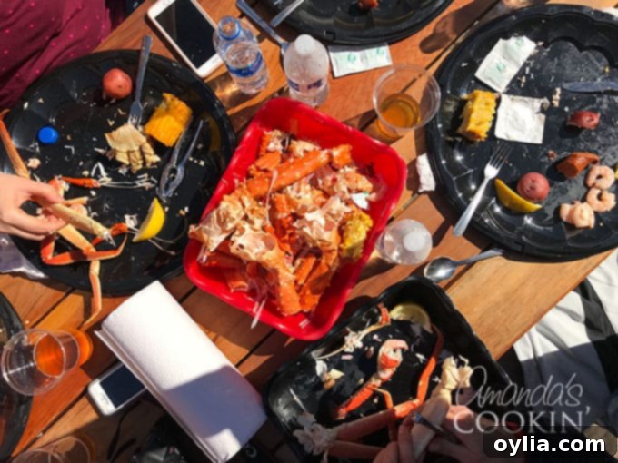 An inviting table laden with a seafood feast, including cracked King crab legs, shrimp, corn, and potatoes.
