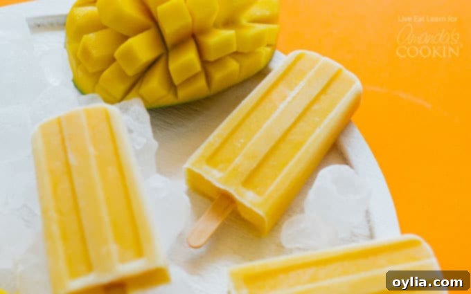 Smooth and creamy Mango Yogurt Popsicles arranged horizontally