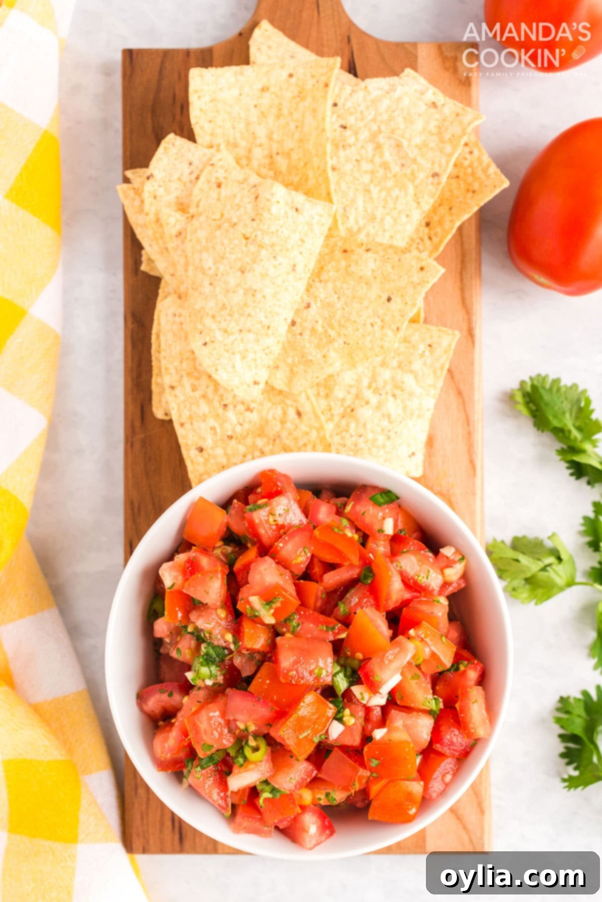 bowl of pico de gallo sitting on cutting board with tortilla chips