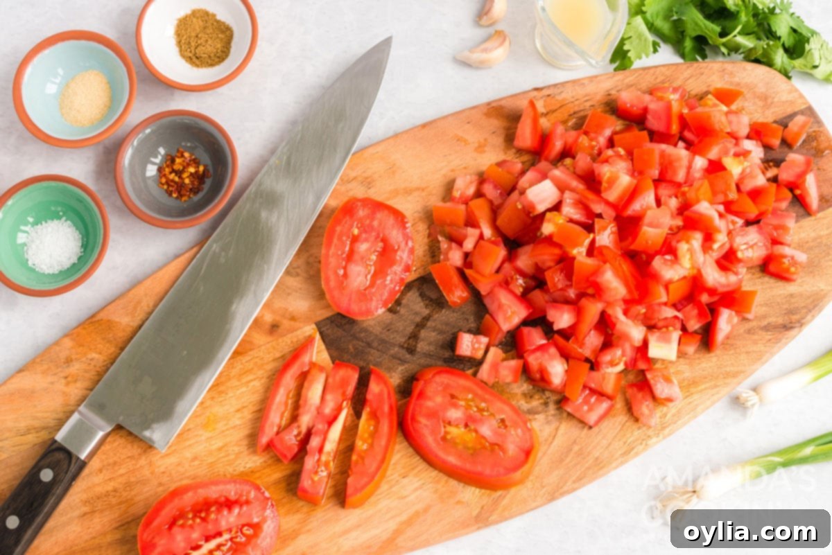 chopped tomatoes and a chefs knife on a cutting board