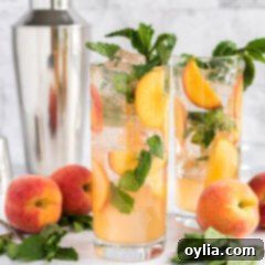 Two beautiful peach mojitos with garnishes.